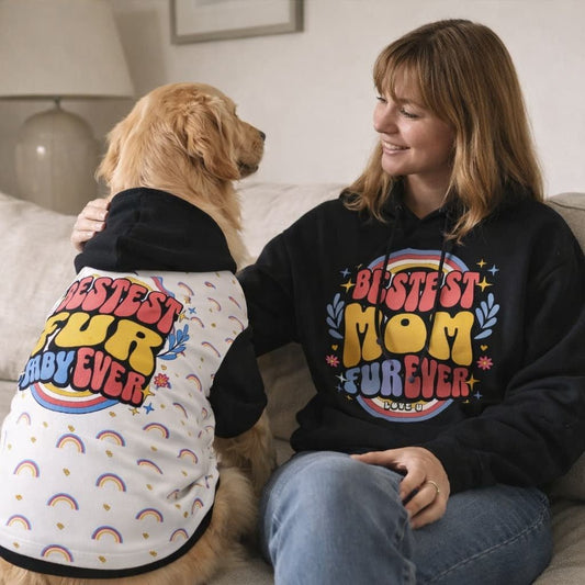 Woman and her dog sitting together wearing matching hoodies