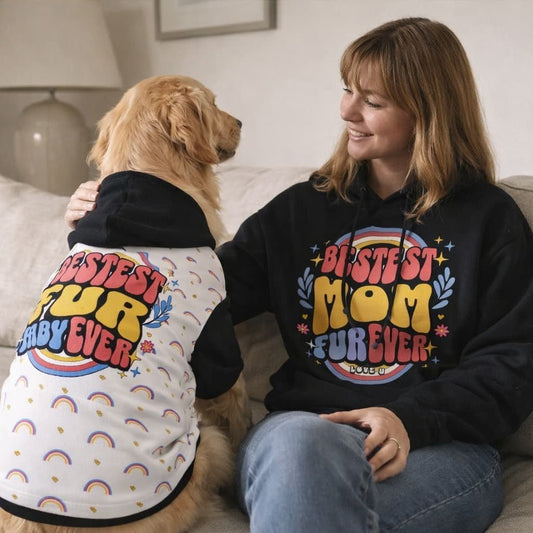 Woman and her dog sitting together wearing matching hoodies