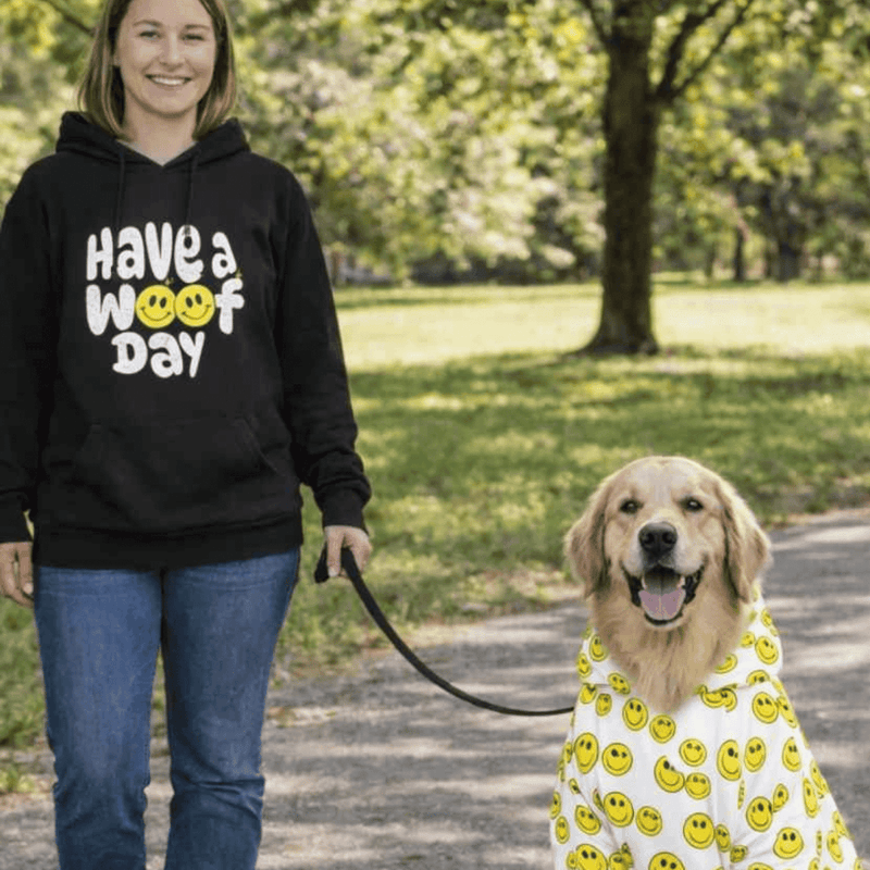 woman walking dog; both are wearing woof design hoodies