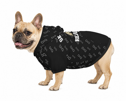 Dog wearing a black hoodie with bone patterns on a white background