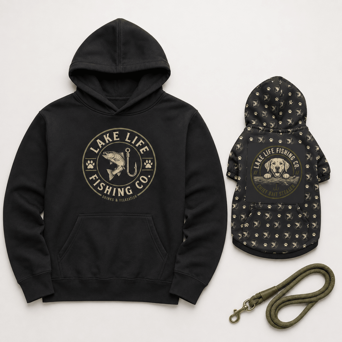 A black hoodie and matching black dog jacket set with a green leash, both featuring a circular 'Lake Life Fishing Co.' graphic on a light gray background.
