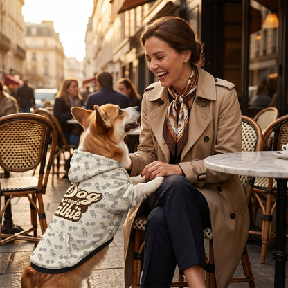 Woman in a trench coat sitting with a dog in a city street setting